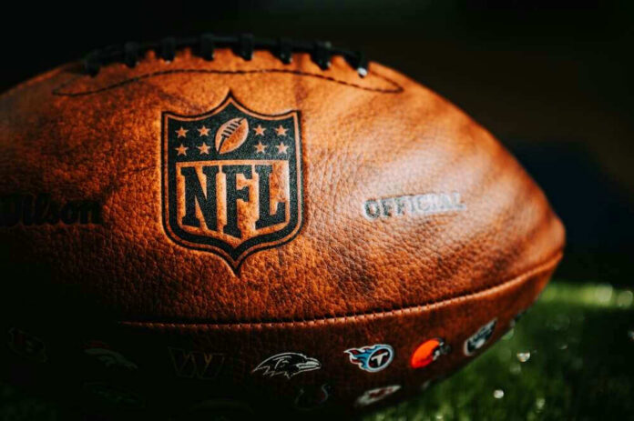 shutterstock_2360713367.jpg Close-up of an NFL football on grass.