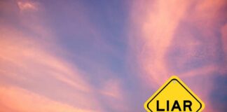 A yellow warning sign with the word 'LIAR' against a colorful sky