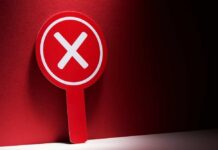 Red sign with a white 'X' symbol against a dark background