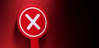 Red sign with a white 'X' symbol against a dark background