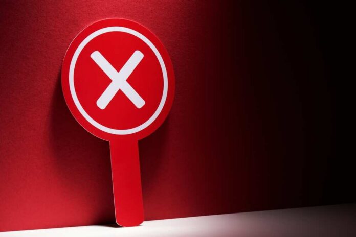 shutterstock_2645833111.jpg Red sign with a white 'X' symbol against a dark background