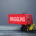 A toy forklift carrying a red shipping container labeled 'SMUGGLING'