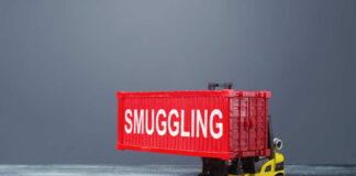 A toy forklift carrying a red shipping container labeled 'SMUGGLING'