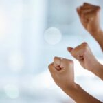 Hands with clenched fists raised in celebration