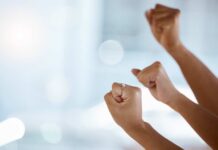 Hands with clenched fists raised in celebration