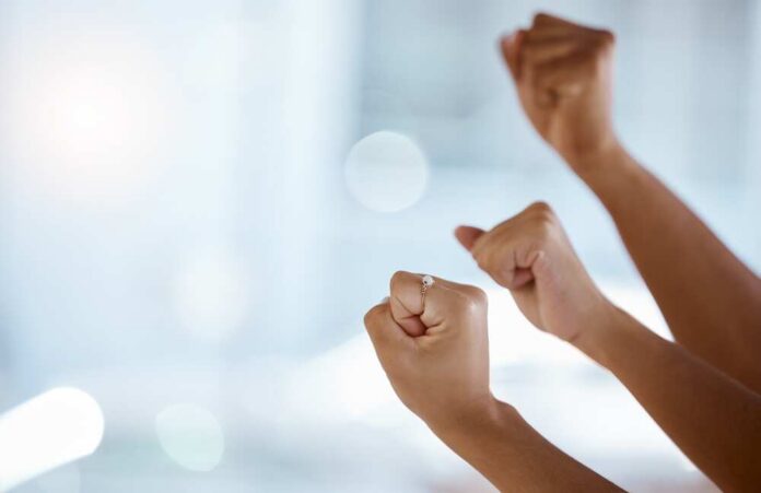Hands with clenched fists raised in celebration