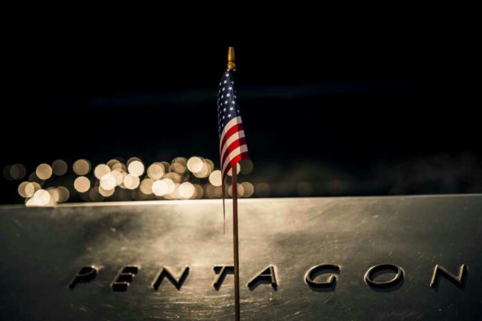 American flag above engraved Pentagon sign at night