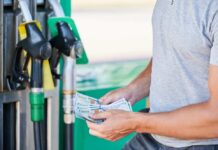Man holding cash at a gas station