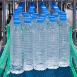 Conveyor belt with rows of bottled water ready for packaging