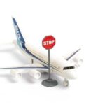 A toy airplane next to a stop sign