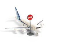 A toy airplane next to a stop sign