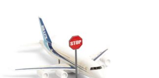 A toy airplane next to a stop sign