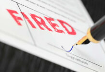 Fountain pen signing document with the word fired