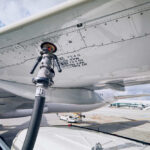 Fueling equipment attached to an airplane wing at an airport