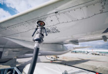 Fueling equipment attached to an airplane wing at an airport