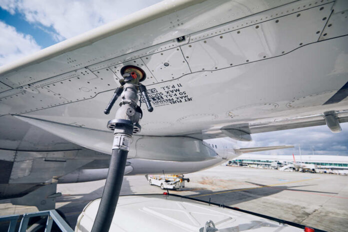 Fueling equipment attached to an airplane wing at an airport