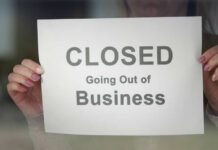 Grocery Giant COLLAPSES — Feds Killed It! A person holding a sign that reads 'CLOSED Going Out of Business'