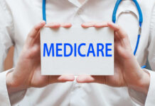 A medical professional holding a sign that says MEDICARE