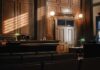 Interior of a courtroom with wooden paneling and green desk lamp