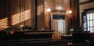 Interior of a courtroom with wooden paneling and green desk lamp