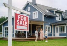 For sale sign in front of a house with potential buyers discussing