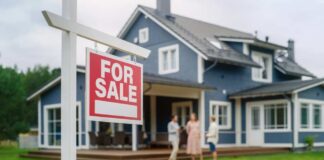 For sale sign in front of a house with potential buyers discussing