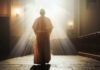 Person in religious attire bathed in sunlight.