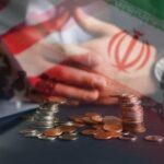 A hand resting on a table with coins stacked in front, overlaid with flags of the US and Iran