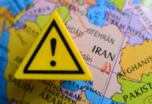 Iran War Shock Threatens Rate Relief A yellow warning sign placed on a map highlighting Iran