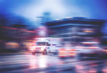 Ambulance speeding through city street at night