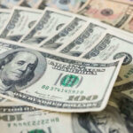 Stacks of various U.S. dollar bills.