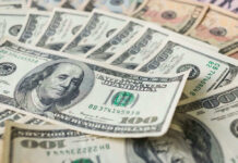Stacks of various U.S. dollar bills.