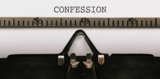 Close-up of a typewriter with the word 'CONFESSION' typed on paper