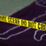 Chilling Discovery: Boxcar Tragedy Yellow crime scene tape marking off an area with a chalk outline