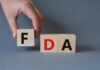 FDA Issues Alert: Pet Food Threat! A hand holding a wooden block with the letter F, next to blocks spelling FDA