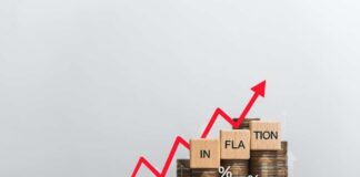 Graph showing inflation trend with coins and wooden blocks