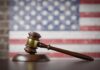 Death Penalty Twist in Double Murder Case A wooden gavel resting on a sound block with an American flag background