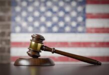 Death Penalty Twist in Double Murder Case A wooden gavel resting on a sound block with an American flag background