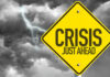 Grocery Crisis: Memorial Day Prices Soar! Yellow sign reading Crisis Just Ahead with stormy sky