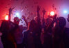 People dancing with confetti at a party.