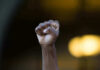 A Hero’s Sacrifice: The Unseen Truth Raised fist in front of blurred background.
