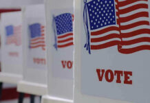 Voting booths with American flags and VOTE signs.