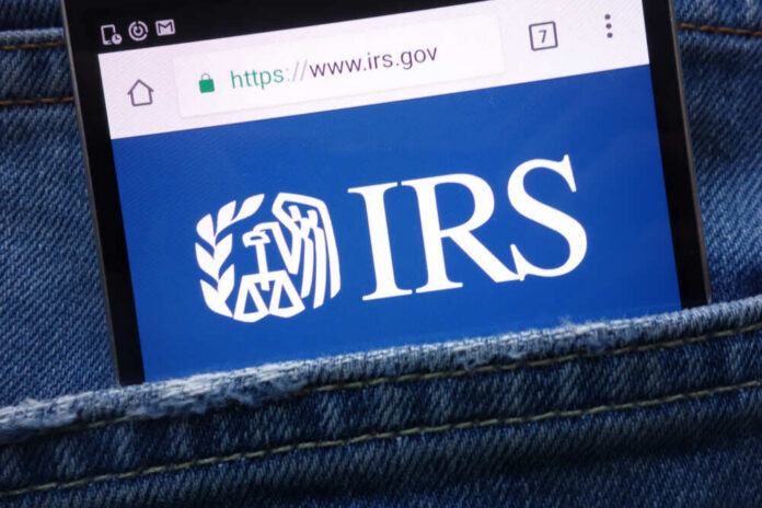 Magnifying glass focusing on IRS website logo.