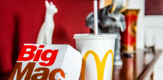 A Big Mac box and a McDonald's drink on a wooden table