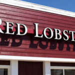 Signage of Red Lobster restaurant against a blue sky