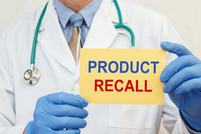 shutterstock_1849024102 Doctor holding a product recall sign in gloves