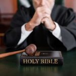 A judge in a courtroom with a gavel and a Holy Bible on the table