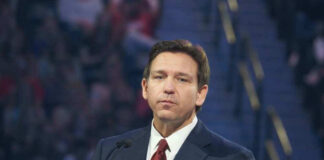 Man in suit speaking at a public event.