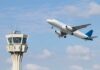 An airplane taking off near an airport control tower