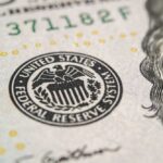 Fed King Dies — Now The Blame War Begins Close-up of a United States dollar bill featuring the Federal Reserve emblem